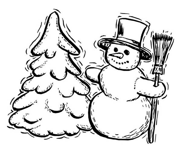 Un enfant jouant dans la neige sous un sapin décoré