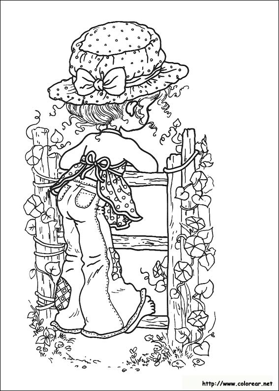 Fille en robe jouant avec un chat dans un jardin fleuri